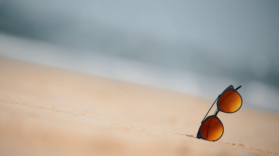Sunglasses lying on the sand of a beach in Goa