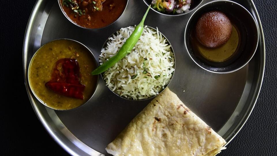 Traditional Indian thali meal with curries, rice and bread served on a metal plate
