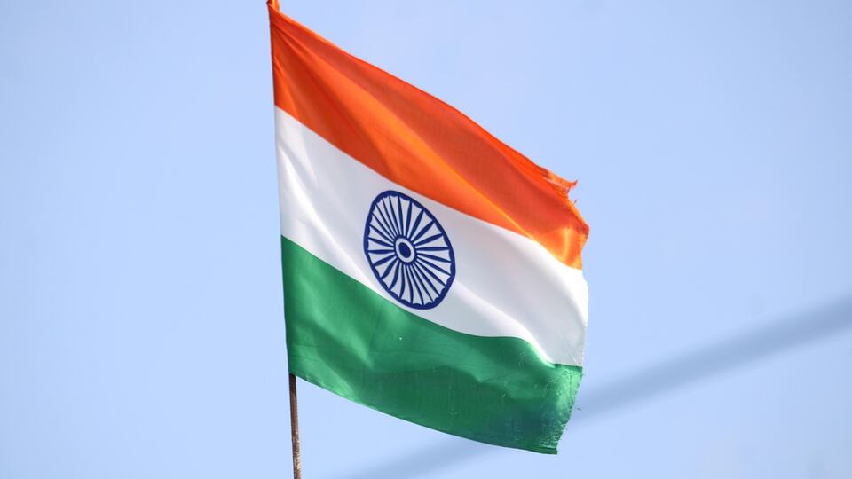 The national flag of India flying against a blue sky