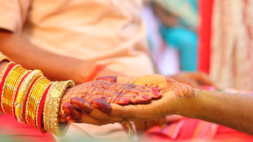 Bride's hands decorated with henna during an Indian wedding ceremony