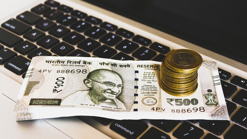 500-rupee banknote with the portrait of Mahatma Gandhi and coins