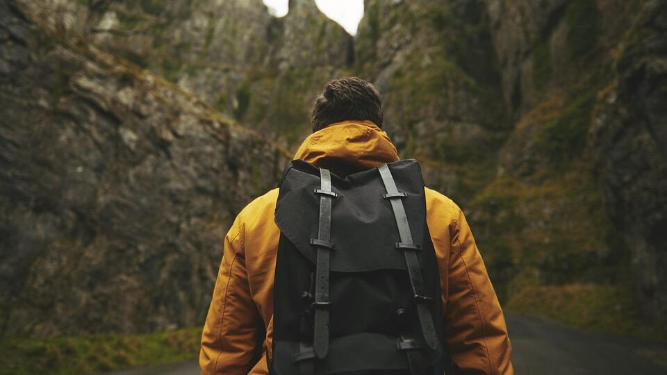 Hiker with a backpack looking out over mountains