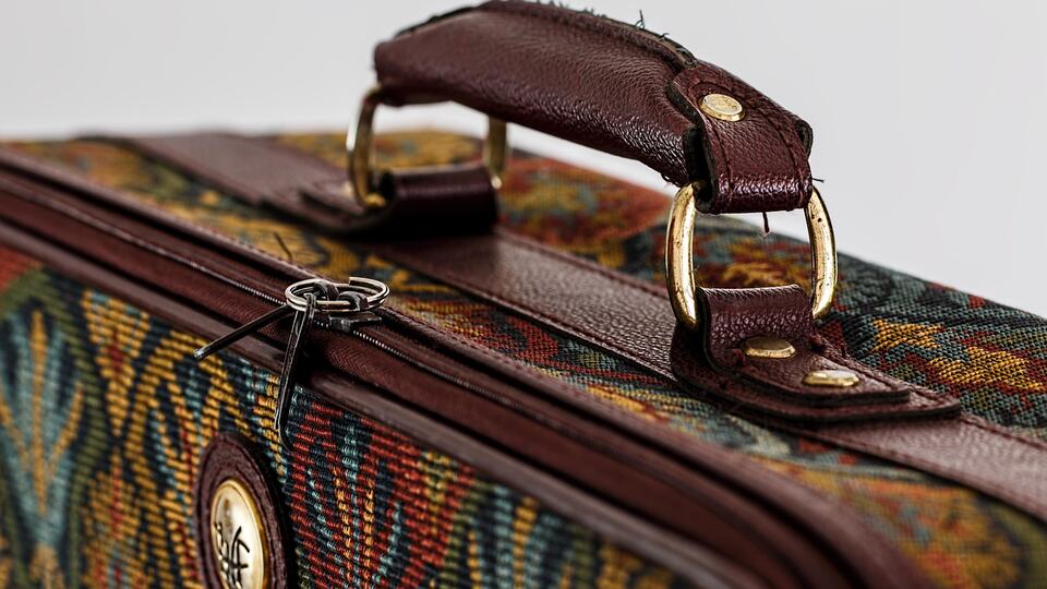 Vintage travel suitcase with a leather handle, ready for a trip to India