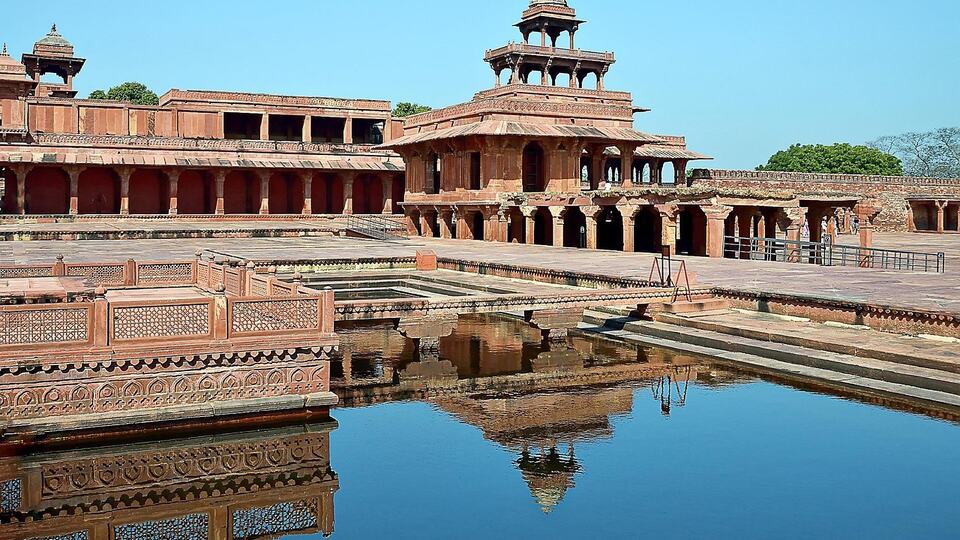 Red sandstone pavilions of Fatehpur Sikri reflected in a palace pool
