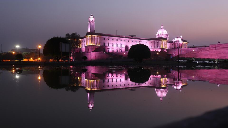 Rashtrapati Bhavan illuminated at night and reflected in water in New Delhi