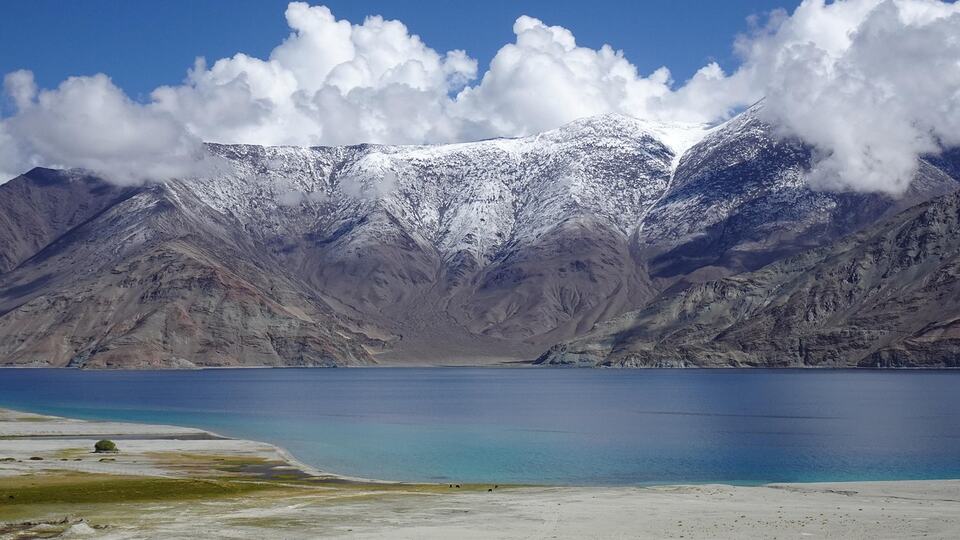 Turquoise waters of Pangong Tso lake framed by snow-capped mountains