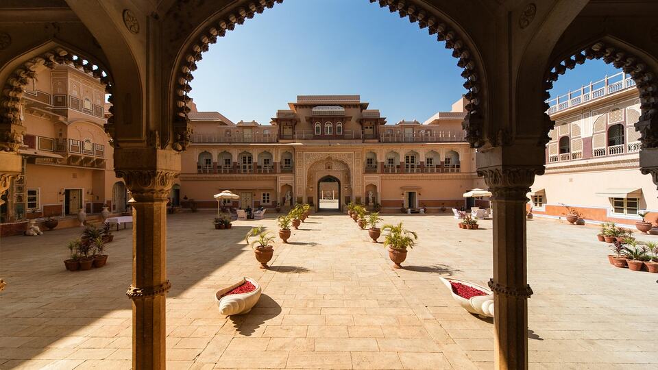 Courtyard of a Rajasthani heritage palace seen through scalloped arches